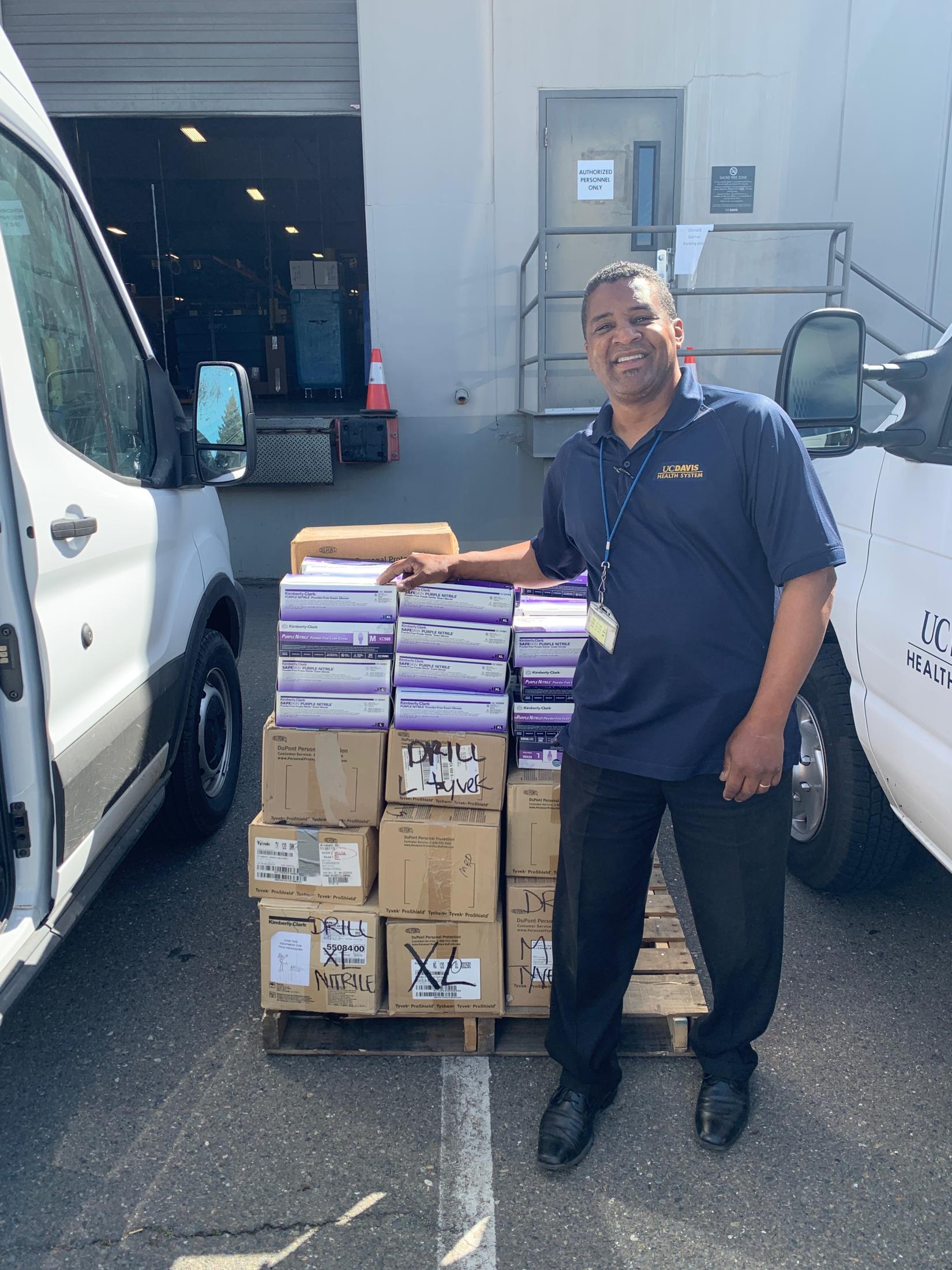 Loren Jenkins, mail services supervisor at UC Davis Health, accepts a donation of personal protective equipment from the School of Veterinary Medicine.