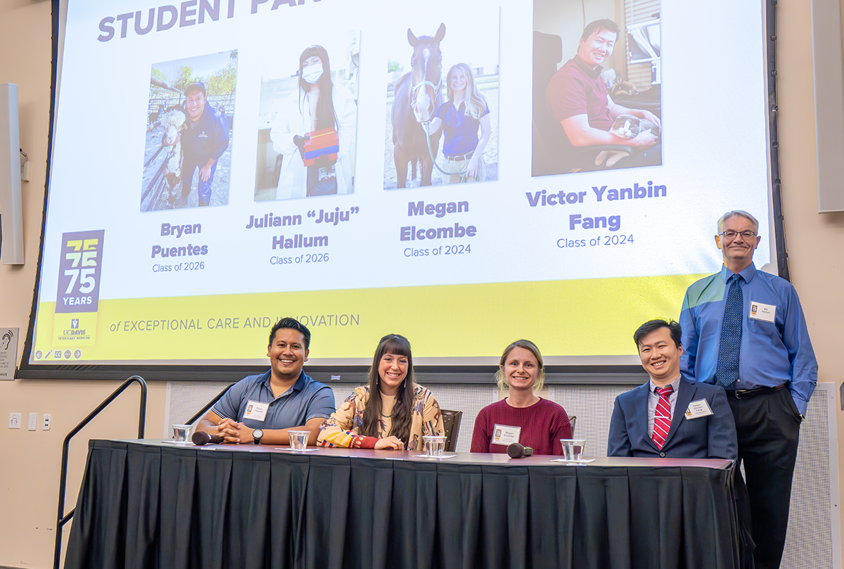Bryan Puentes, Class of 2026; Juliann “Juju” Hallum, Class of 2026; Megan Elcome, Class of 2024; Victor Yanbin Fang, Class of 2024 sit at a table to give presentations.