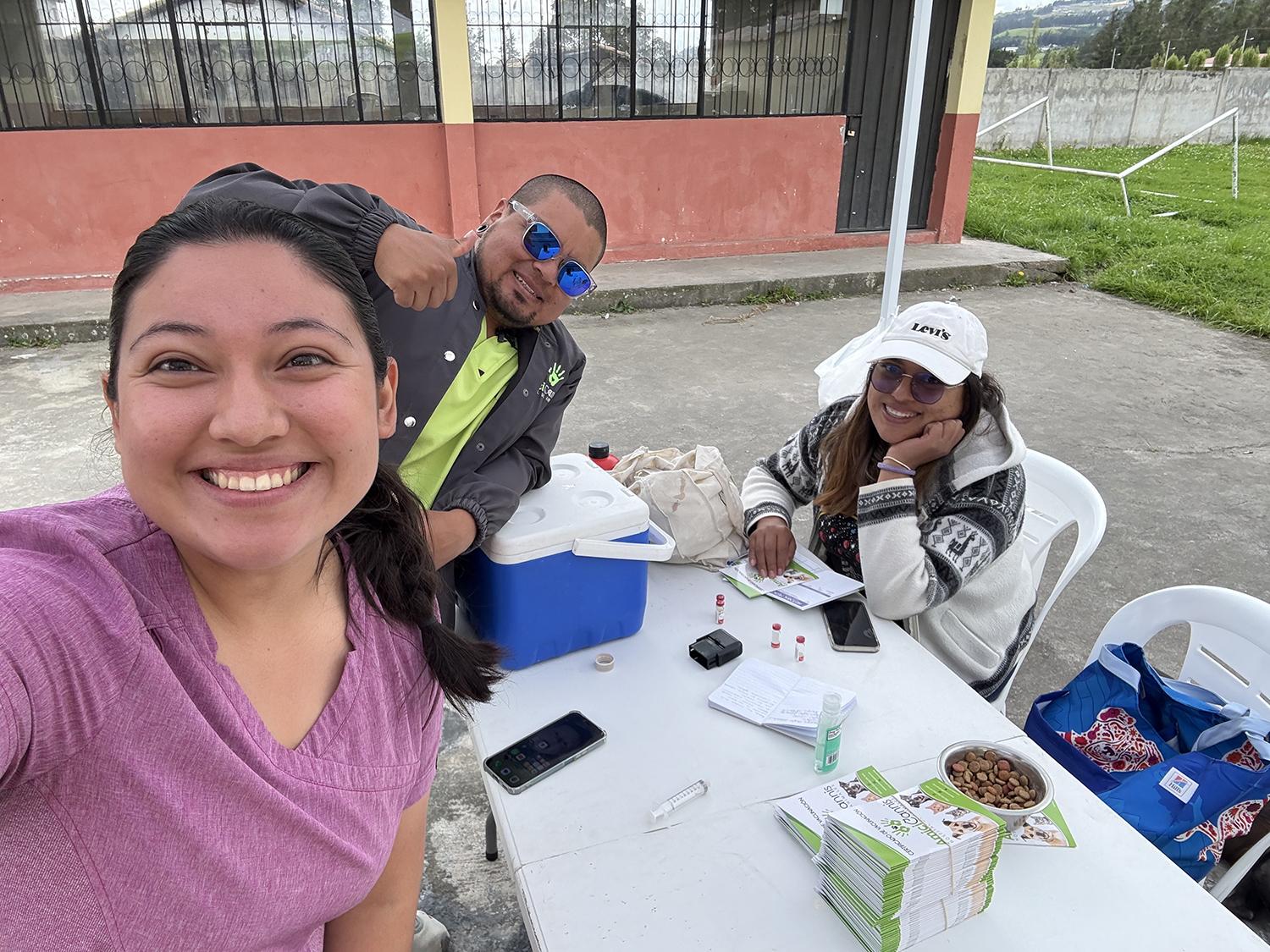 Three people eating food at a table.