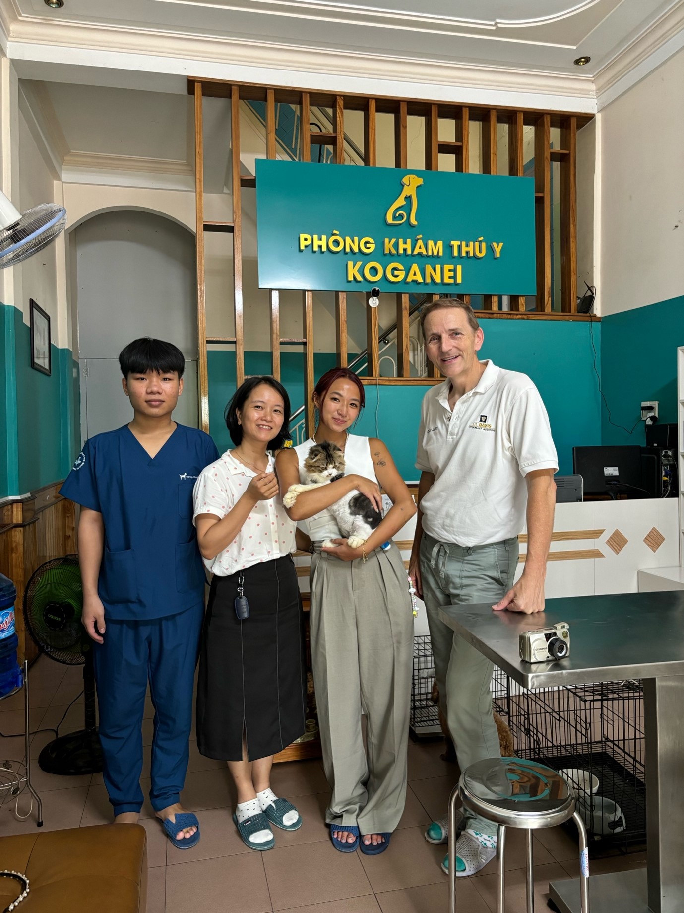 Nhung holding a cat, standing with 3 other vets.