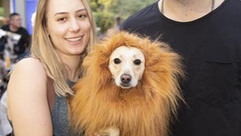students with lion-costumed dog