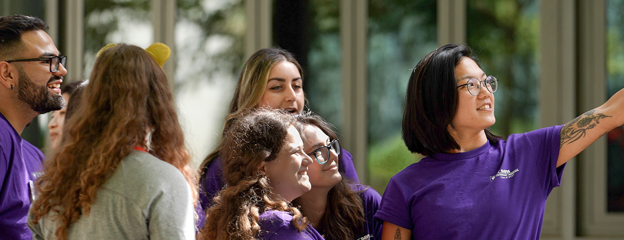 A group of students gather together for a phone selfie.