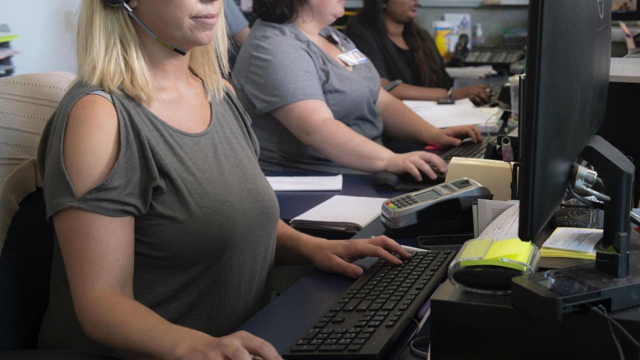 Client service representatives check-in patients at one of three reception areas at the UC Davis veterinary hospital. UC Davis veterinary call center client service representative