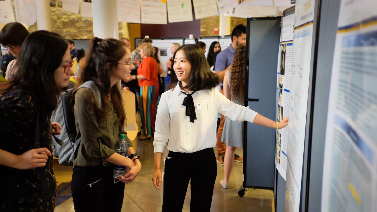 student presents research at a poster session