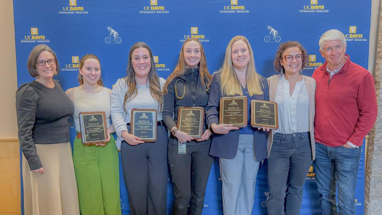 group of veterinarians holding award plaques