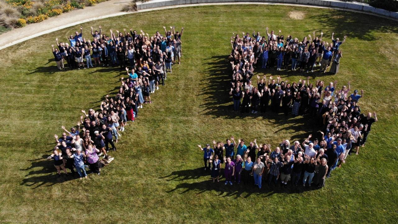 drone photo of people in shape of 75