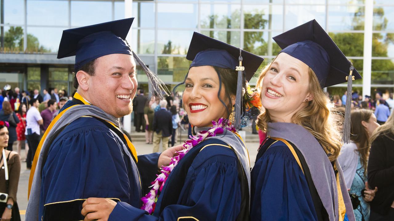 three students at commencement 2019