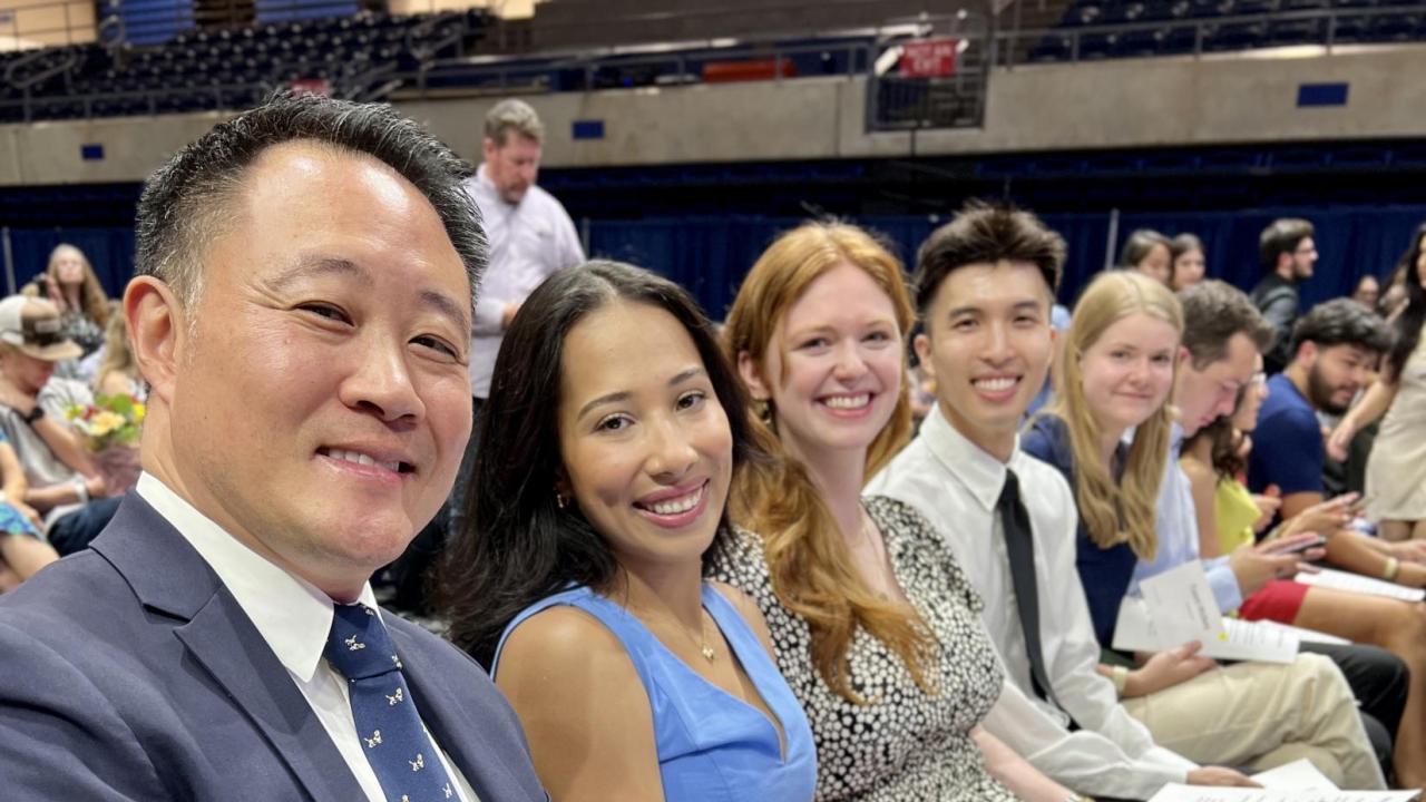 Group of students at white coat ceremony sitting in a row