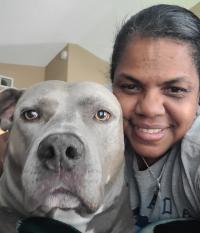 dog and woman looking closely into camera