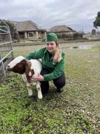 girl in 4-H uniform with goat