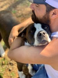 dog being hugged by man