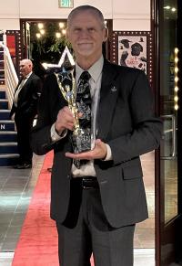 Man with award on red carpet
