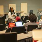 Dr. Gina Davis sitting in a classroom addressing students during a VOICE lunch talk